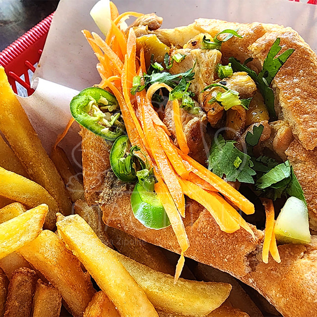 Bánh Mì – Sándwich tradicional vietnamita con paté, verduras en escabeche, mayonesa, cilantro & pollo o cerdo a la parrilla – acompañado con papas fritas / Traditional Vietnamese sandwich with paté, pickled vegetables, mayonnaise, cilantro & grilled chicken or grilled pork - fries on the side 

