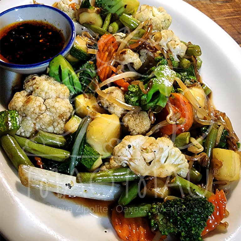 Pad Puk - Salteado de verduras mixtas y verduras asiáticas locales (cuando esté disponible) con ajo, soya & aceite de ajonjolí. Disponible tradicional o vegano (v)