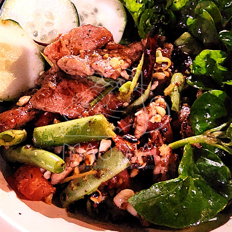 Tum Kor Moo**+ -  ensalada semifría con cerdo a la parrilla (180g), tomate, ejote, limón, chiles & cacahuates